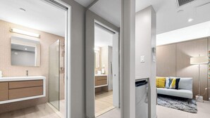 A modern bathroom with a glass shower enclosure, a vanity with a mirror, and a toilet. - Wave Front Escape | Trendy Studio in Condado (San Juan)