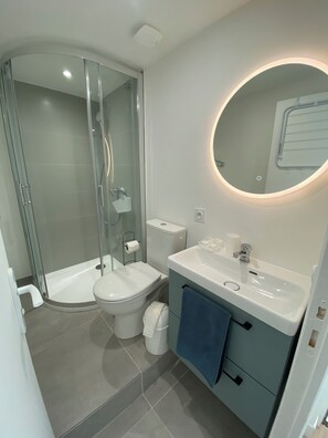 Eenvoudig appartement | Badkamer | Een douche, een haardroger, handdoeken, zeep