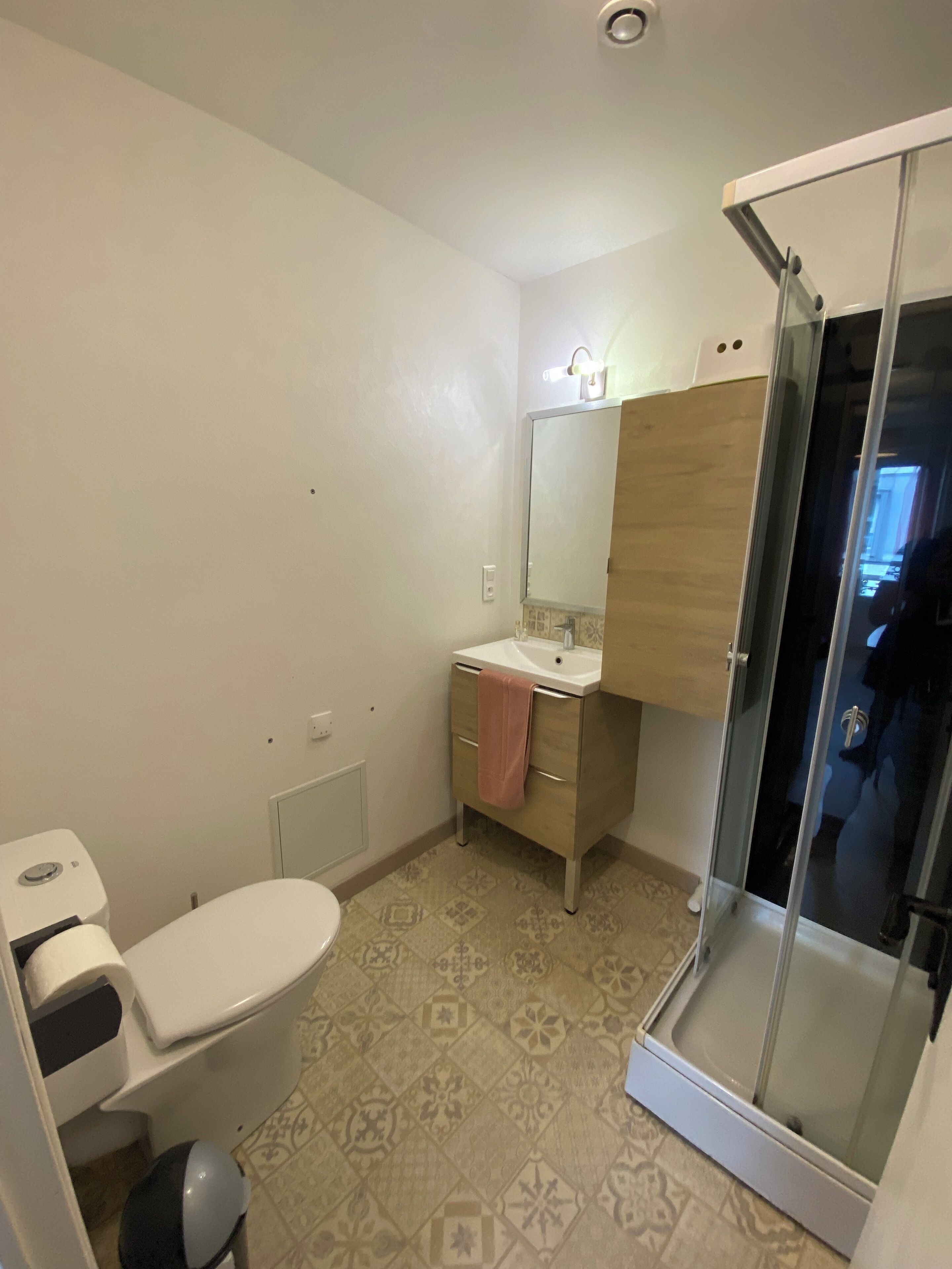 Ein Badezimmer mit Toilette, Waschbecken, Spiegel und Dusche.