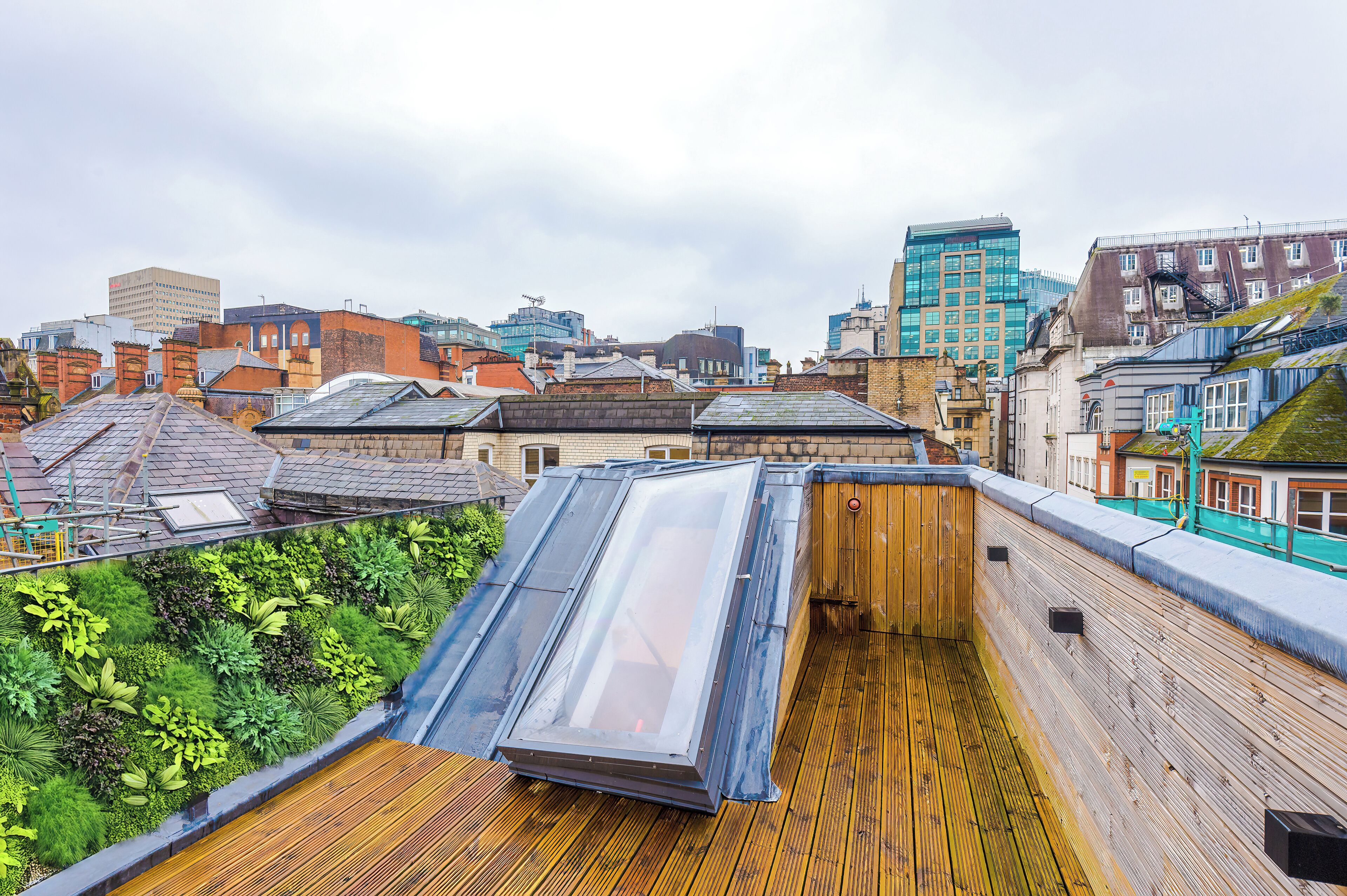 A rooftop with a wooden deck and a large skylight.