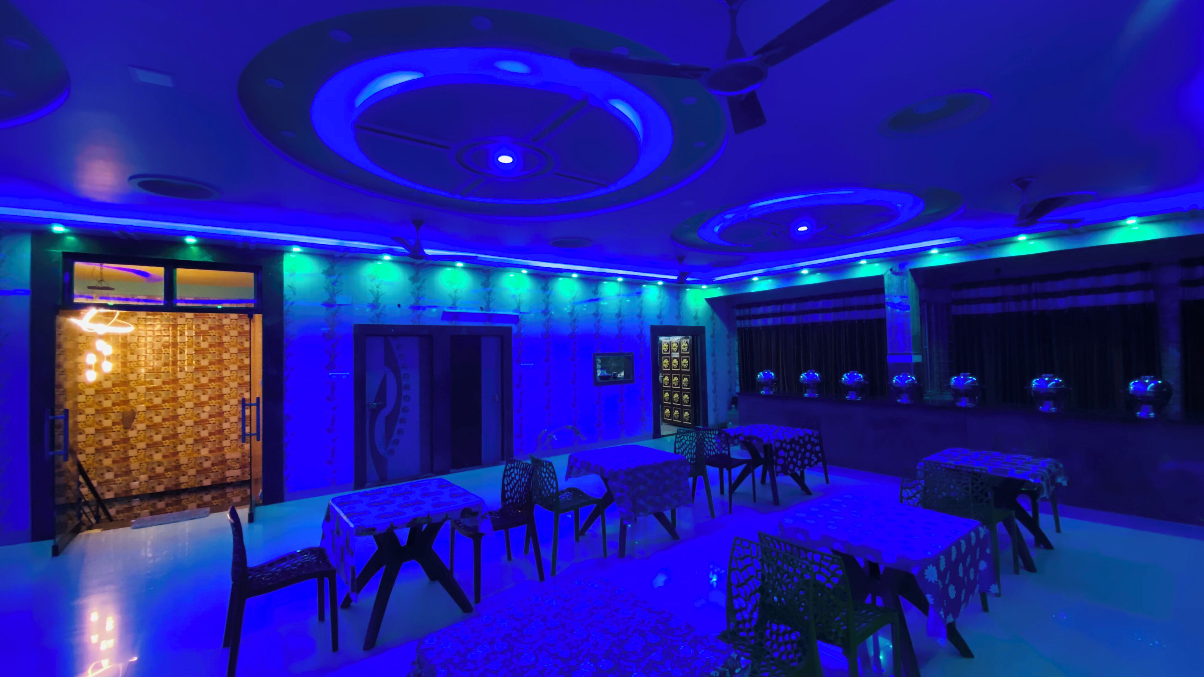 A room with a ceiling design, a patterned wall, and a door with a glass panel.