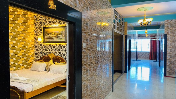 Habitación de hotel con cama, pared con diseño geométrico, un cuadro y una lámpara de araña.