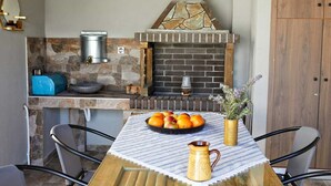 Een keuken met een steenschildering, een bakoven en een tafel met fruit en een karaf.