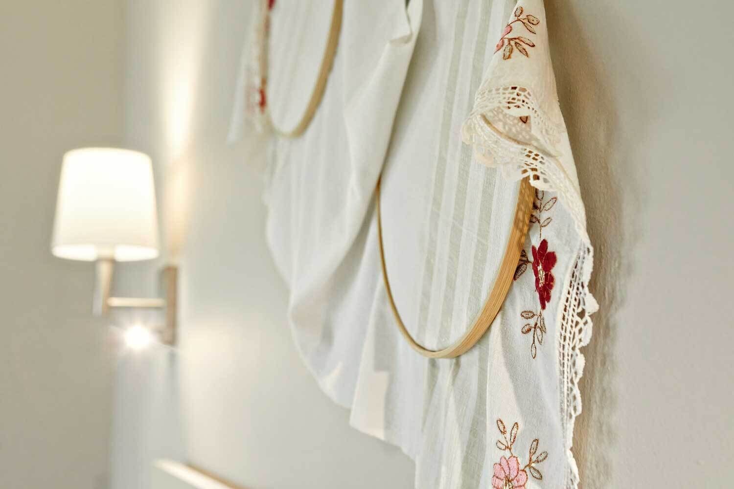Pared blanca con una toalla colgada y una lámpara de pared.
