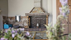 Een keuken met een achterwand van steen, een bakoven en een blauw apparaat.