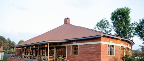 Un bâtiment en briques doté d’un toit incurvé et d’un porche abrité.