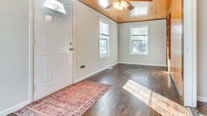 A spacious room with hardwood floors, a ceiling fan, and a large window. - Hike, Boat & Fish: Dog-friendly Robinson Home (Robinson)