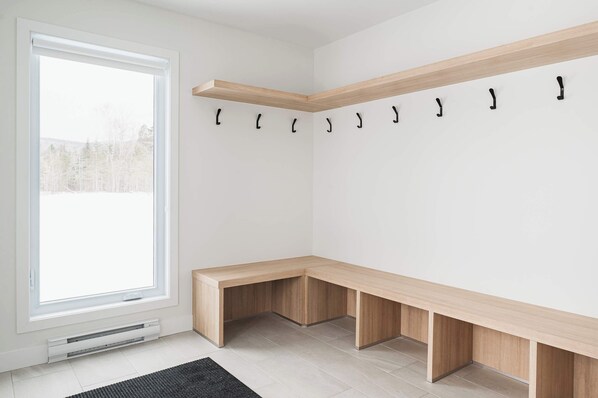 A corner room with a built-in bench and a wall-mounted coat rack. - Spa and Mountain | Villas Perspective | Alphonse (Beaupré)