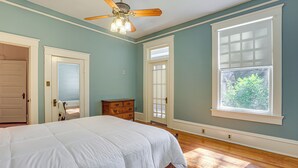 A bedroom with a large bed, a ceiling fan, and a window with a view of greenery. - 1 Mi to Dtwn Meridian: Historic Home w/ Porch! (Meridian)