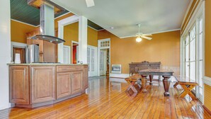 A spacious kitchen with wooden cabinets, a central island, and a dining area with a table and chairs. - 1 Mi to Dtwn Meridian: Historic Home w/ Porch! (Meridian)