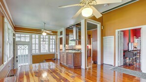A spacious kitchen with wooden flooring, a central island, and a ceiling fan. - 1 Mi to Dtwn Meridian: Historic Home w/ Porch! (Meridian)
