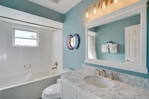 A modern bathroom with a bathtub, a sink, and a mirror. - Laid-back Luxury: Home w/ Pool Near Bowmans Beach (Sanibel)