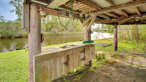 Una struttura in legno rustica con un lavandino e una panca, situata vicino all'acqua.