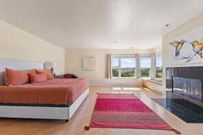 Una camera da letto con un letto, una finestra, un balcone e un quadro.