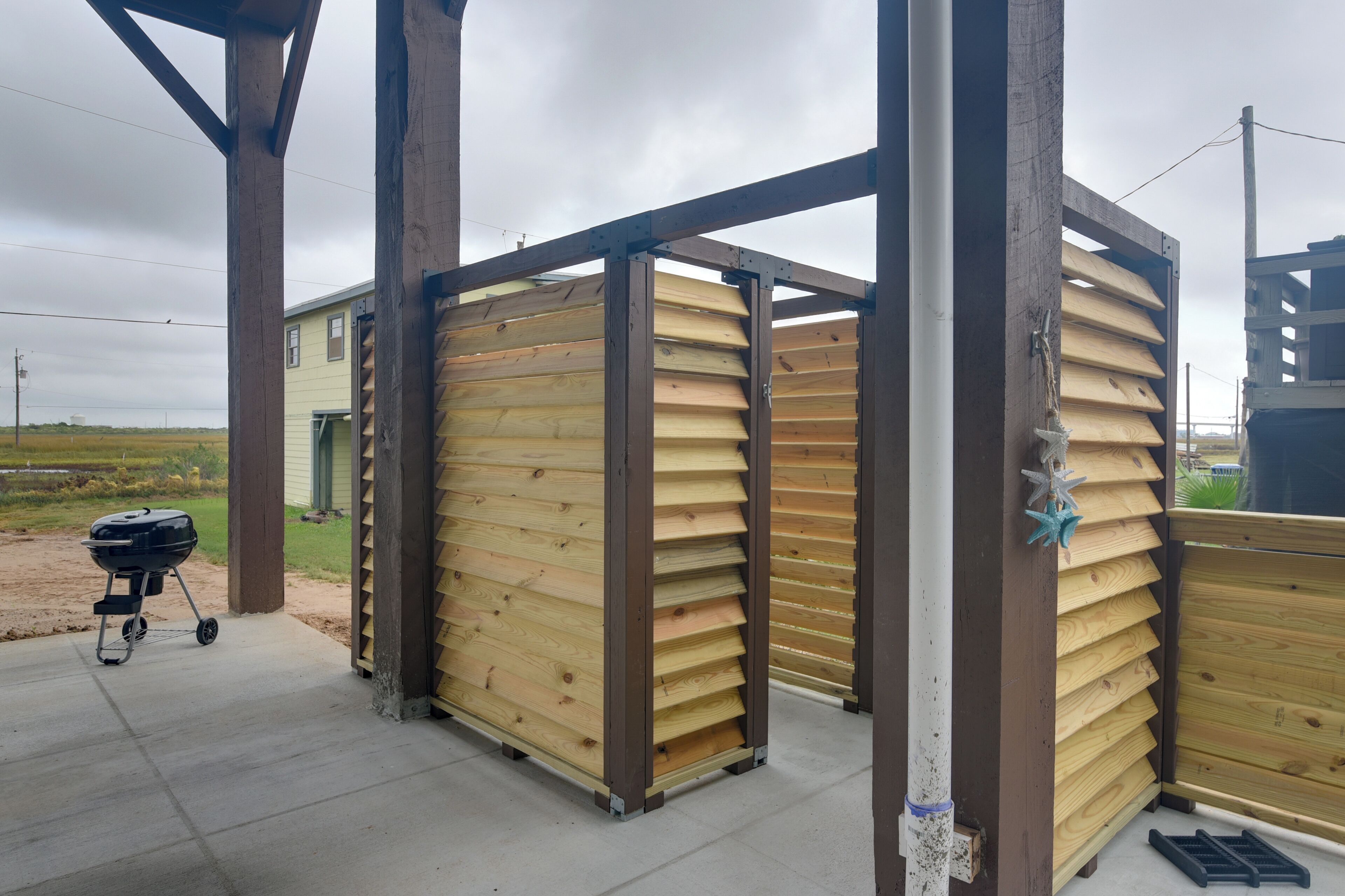 A wooden structure with a grill and a covered area, possibly a patio or outdoor seating area.