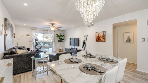 A modern living room with a dining area, white walls, and a chandelier. - Furnished Patio, Pool Access! Scottsdale Retreat (Scottsdale)