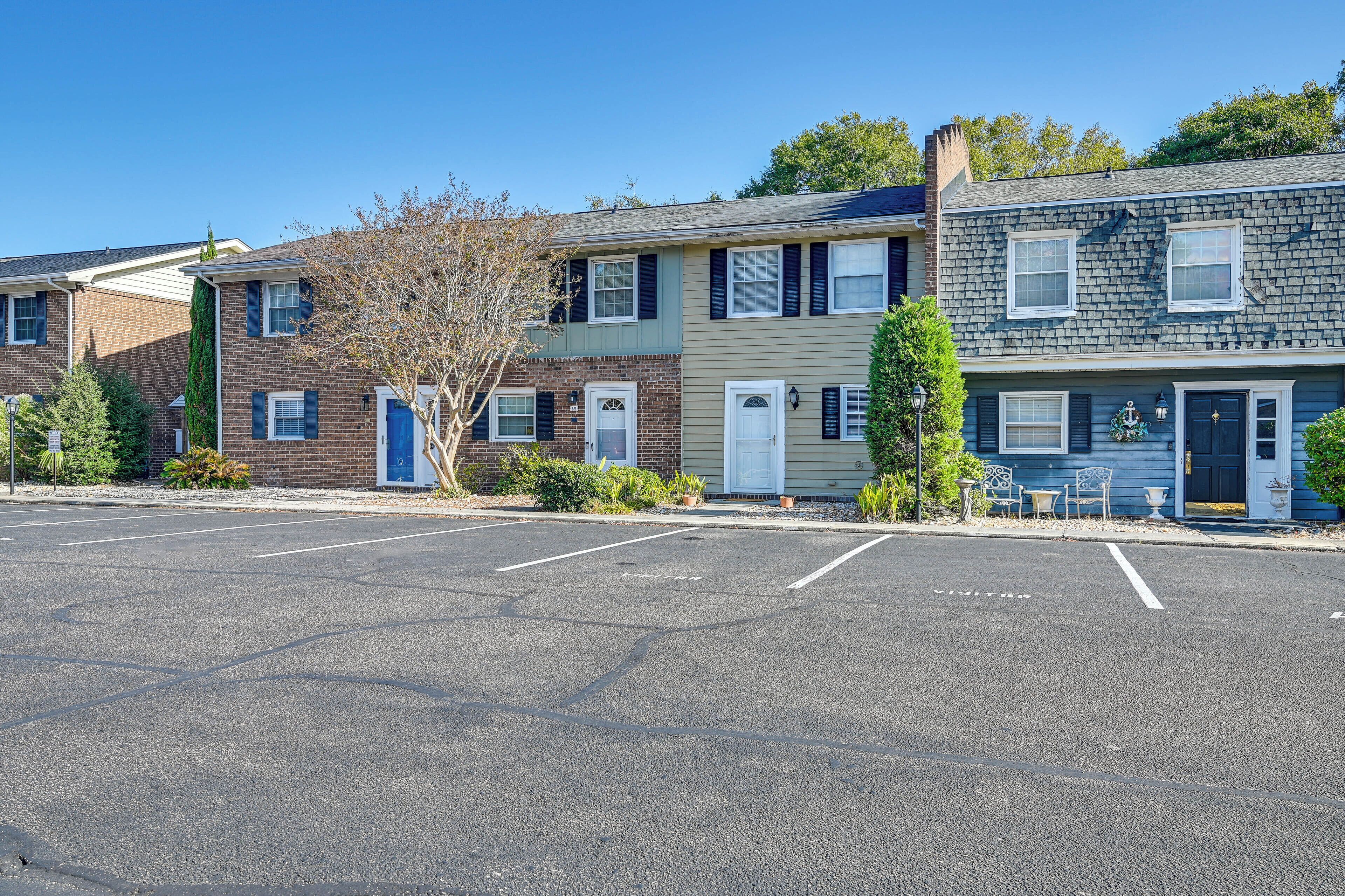 A row of townhouses with a parking lot in front.