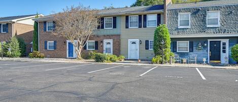 A row of townhouses with a parking lot in front.