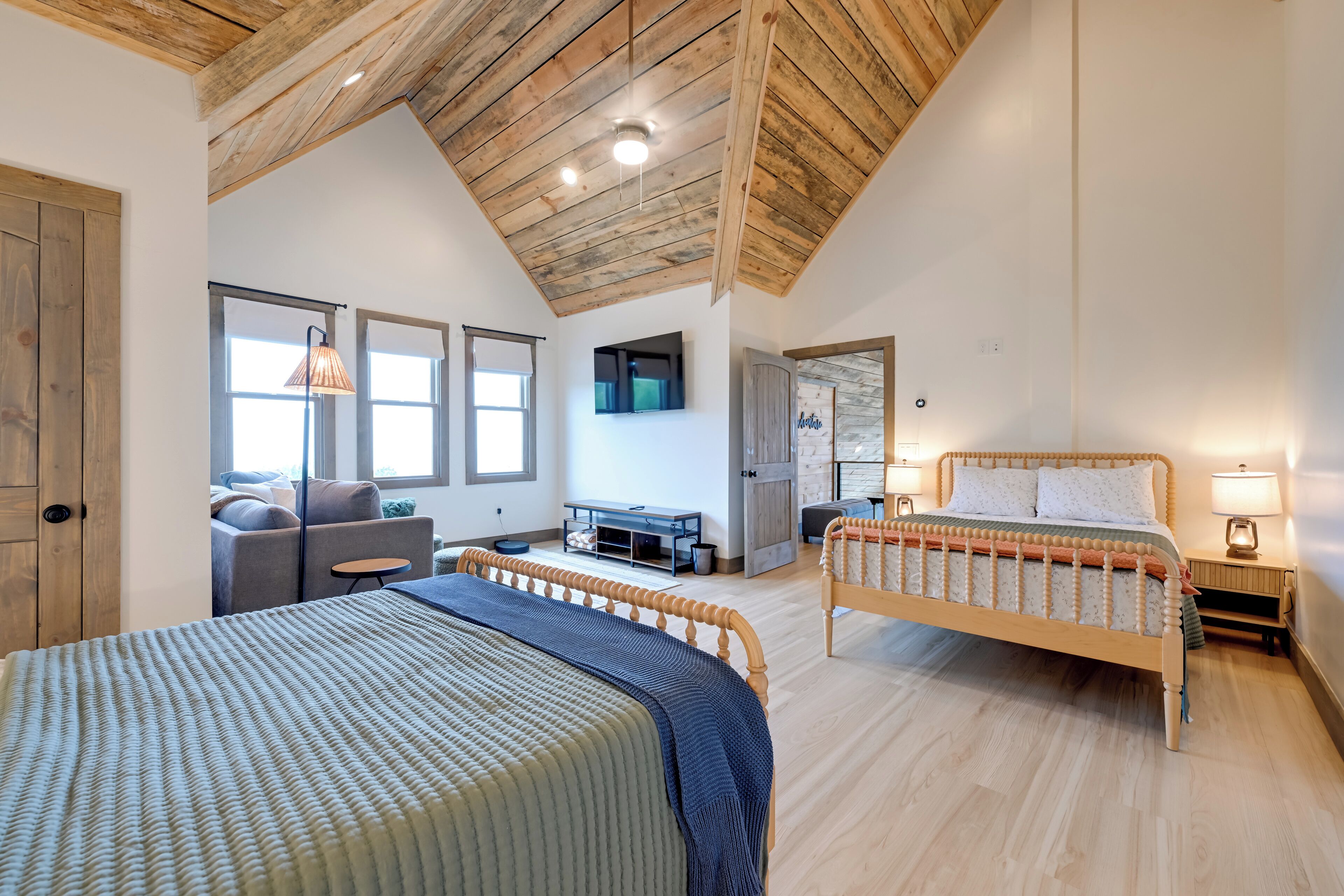 Une chambre avec deux lits, un bureau, un canapé et une télévision.