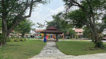 A park with a gazebo, a concrete pathway, and trees.