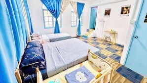 Un dormitorio con dos camas, una mesita de noche, una silla, una pequeña mesa y una puerta.
