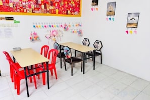 A classroom with tables and chairs, educational posters, and a large red poster on the wall. - Backyard Garden Villa (Petaling Jaya)