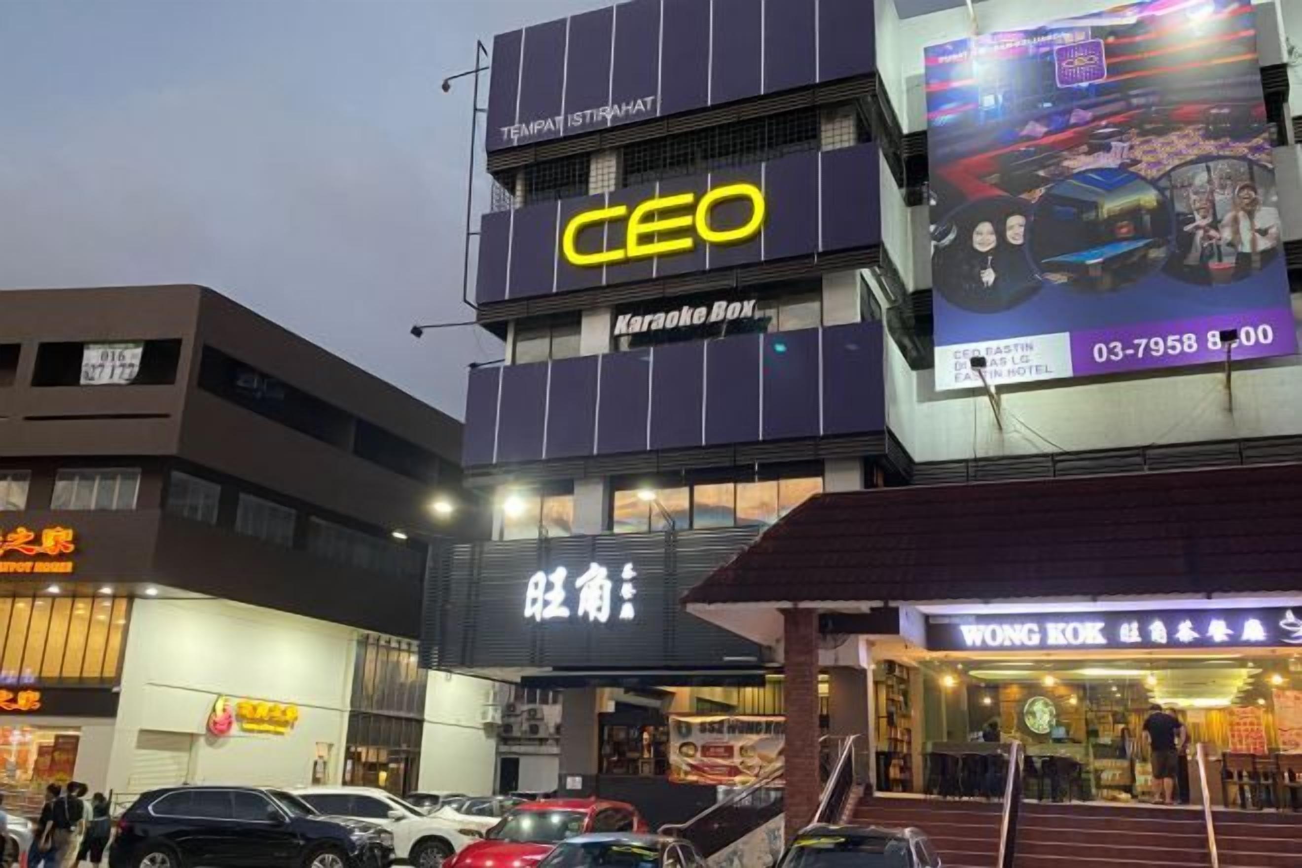 Un edificio de varios pisos con letreros que indican 'CEO Karaoke Box' y 'WONG IOK'.