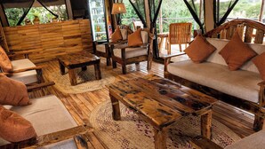 A rustic wooden interior with a sofa, chairs, and a coffee table. - Seregenti Kifaru Tented Lodge (Serengeti)