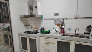 A compact kitchen with a gas stove, a stainless steel sink, and a small countertop.