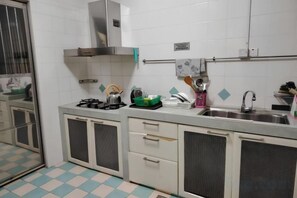 A kitchen with a gas stove, sink, and cabinets. - Natol Homestay - Sydney Batu Kawa Mjc New Townships (Kuching)