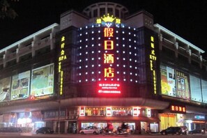 A building with illuminated signage, multiple floors, and a prominent entrance.