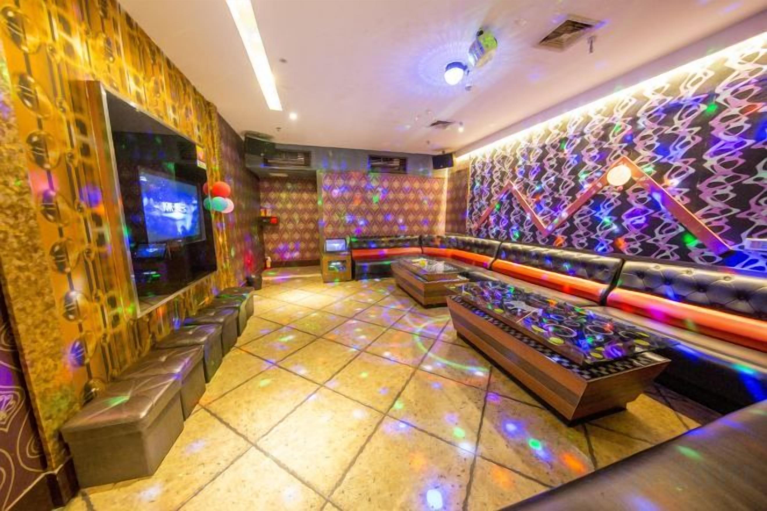 A room with a bar area, a television, and patterned walls.