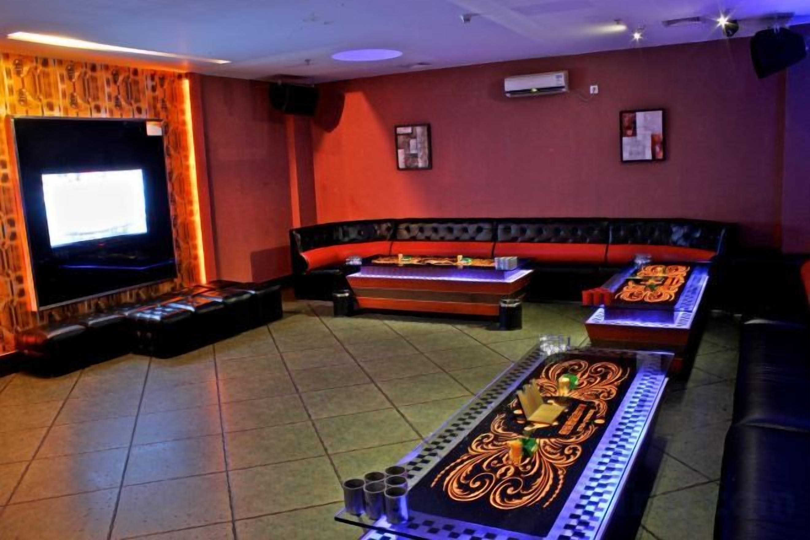 Una habitación con televisión, un sofá y una mesa con camino de mesa decorativo.