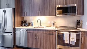 A modern kitchen with stainless steel appliances, a microwave, and a dishwasher. - Private Downtown Seaport Apt with Pool (Boston MA)
