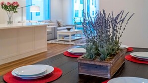 A modern kitchen with a wooden island, red placemats, and a potted plant. - Private Bedroom With Bathroom Central Location (Santa Ana)