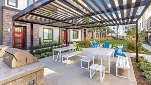 An outdoor patio with a grill, white benches, and blue chairs. - Private Bedroom With Bathroom Central Location (Santa Ana)