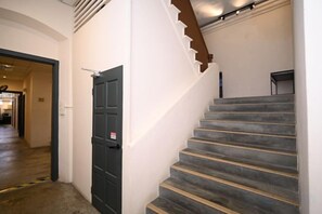 Eine Treppe mit Geländer und einer Tür mit einem Schild.