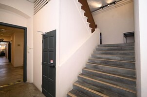A staircase with a handrail and a door with a sign.