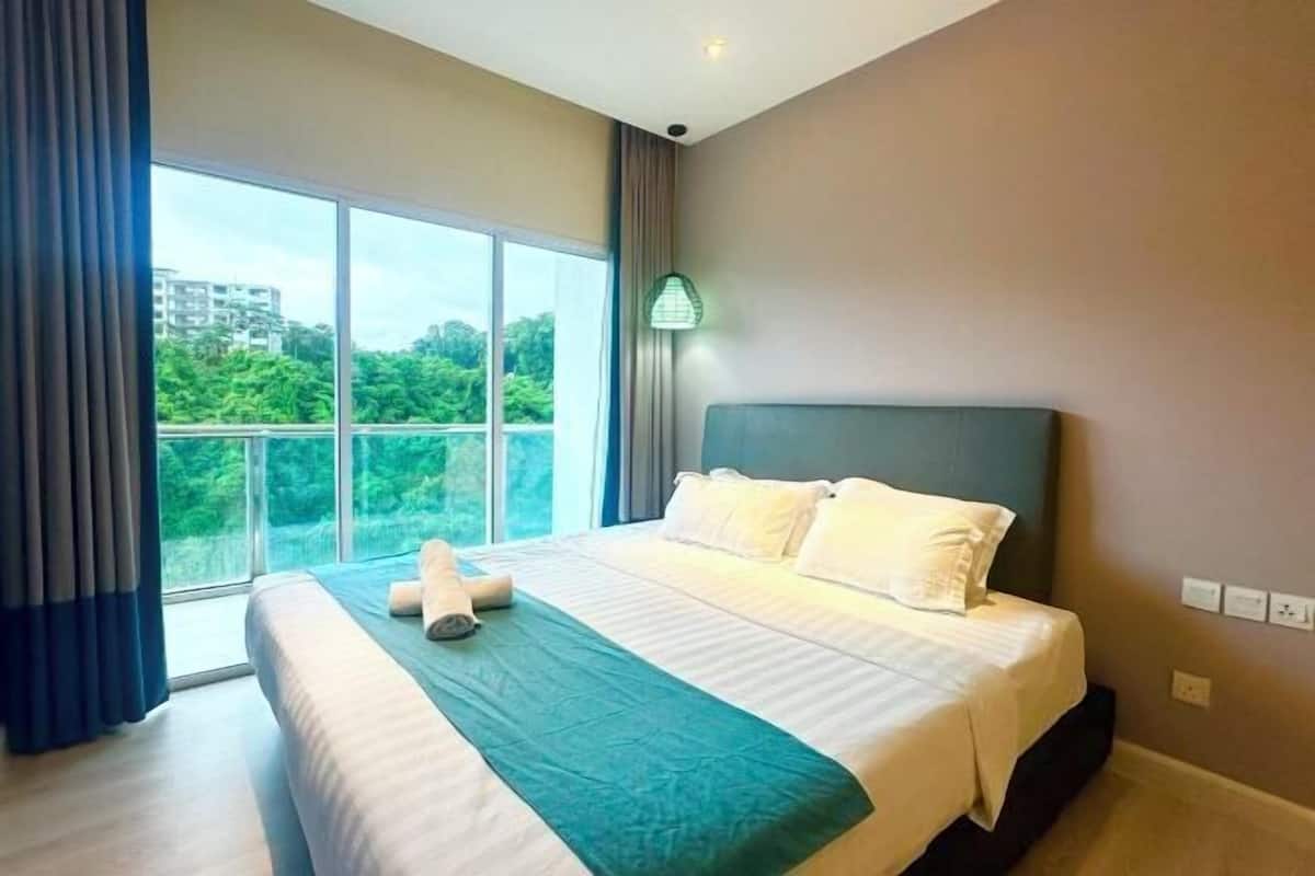 Una camera d'hotel con un'ampia finestra, un letto con biancheria bianca e una coperta verde acqua.