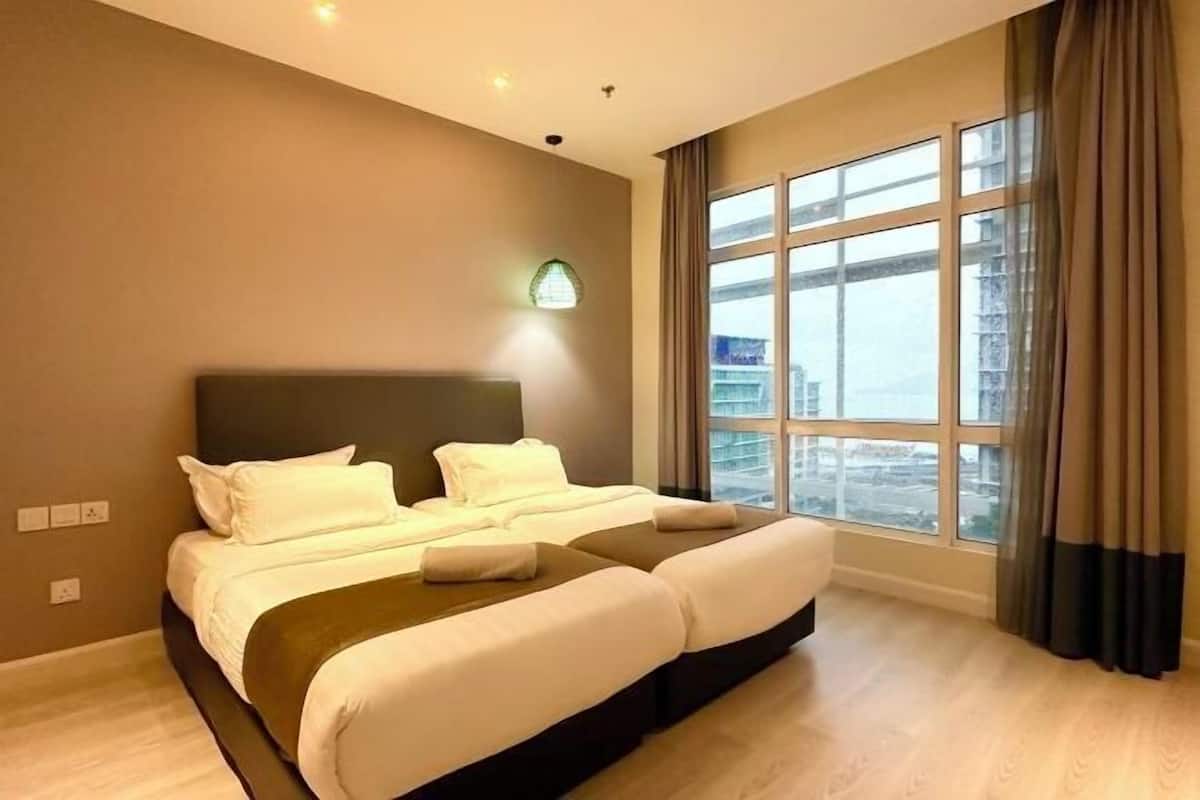 Una camera d'albergo con un letto grande, vista sulla città e una finestra con tende.