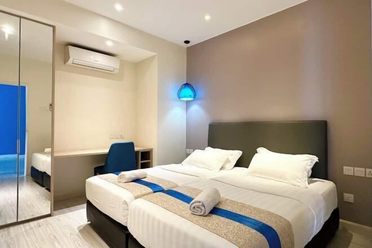 Una camera d'albergo con un letto, una scrivania e uno specchio.