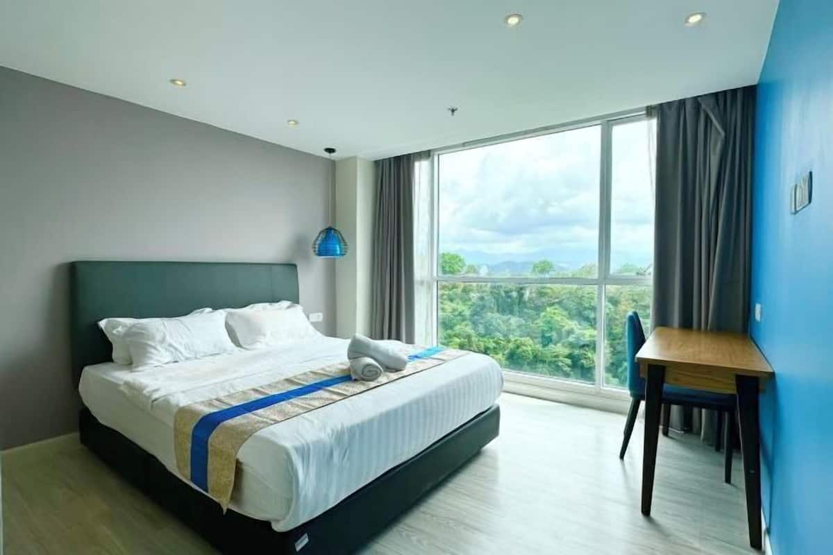 Una camera d'albergo moderna con un letto grande, una scrivania e vista sull'esterno.