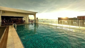 An indoor swimming pool with a bar area and seating, surrounded by a glass railing. - M Centro City Centre @ Gaya Street by Ssvc (Kota Kinabalu)