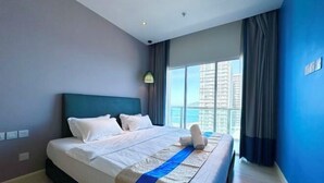 A hotel room with a large bed, a view of tall buildings, and a window with curtains. - M Centro City Centre @ Gaya Street by Ssvc (Kota Kinabalu)
