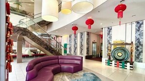 A modern lobby with a curved purple seating area, a staircase, and red lanterns. - M Centro City Centre @ Gaya Street by Ssvc (Kota Kinabalu)