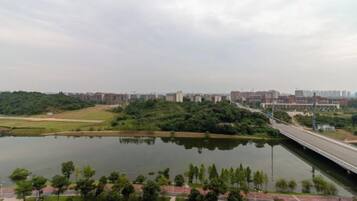 A river with a bridge, a parking lot, and buildings in the background.