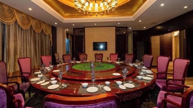 A conference room with a round table, purple chairs, and a chandelier. - Tenglong Hotel (Zhuzhou)