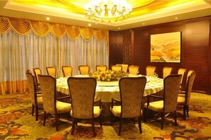 A conference room with a round table, chairs, and a chandelier. - Tenglong Hotel (Zhuzhou)