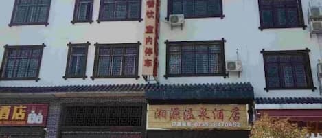 A multi-story building with several shops on the ground floor.
