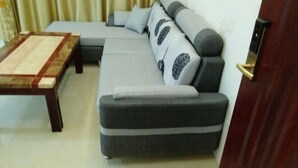 Uma sala de estar com sofá, mesa de centro e uma porta.
